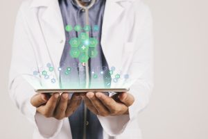 Médico con tablet en las manos y con información digital sobresaliendo.