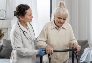 Profesional de la salud asiste a una mujer mayor en su rehabilitación física tras un ACV.
