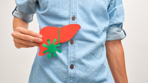 Persona mostrando una ilustración del hígado con un virus, simbolizando la hepatitis y su impacto en la salud hepática.