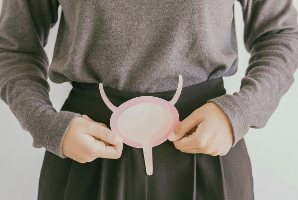 Persona sosteniendo una ilustración de la vejiga humana a la altura del abdomen, en referencia al cáncer de vejiga y urológico superior.