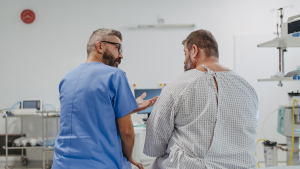 Profesional sanitario hablando con un paciente con obesidad en una consulta hospitalaria, ilustrando la paradoja de la obesidad.
