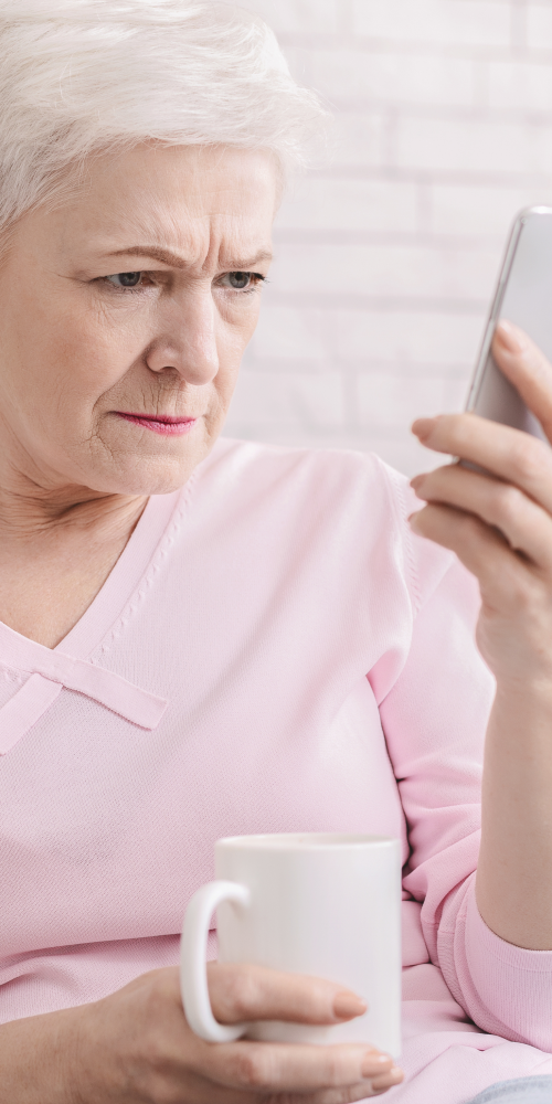 Persona adulta con dificultad para ver con claridad la pantalla del móvil, representando síntomas del edema macular diabético en personas con diabetes