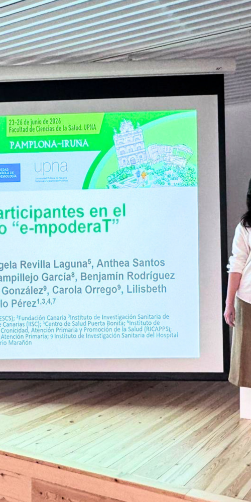 Vanesa Ramos García y Lilisbeth Perestelo-Pérez junto a la diapositiva del ensayo clínico e-mpoderaT durante la Reunión Anual SEE 2026, celebrada en la Universidad Pública de Navarra.